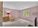 Living room with pink walls, a brick wall, and windows providing natural light at 740 Skyline Dr, Covington, GA 30014