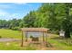 Relaxing outdoor space featuring a wooden swing with a tennis court and lush greenery at 740 Skyline Dr, Covington, GA 30014