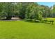 Expansive green lawn with mature trees offers a peaceful and private setting with outbuildings at 740 Skyline Dr, Covington, GA 30014