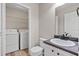 Powder room with vanity, mirror, toilet, and laundry area at 1333 Laura Ln, Austell, GA 30168