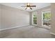 Spacious bedroom with plush carpeting, ceiling fan, and natural light from the large double windows at 1333 Laura Ln, Austell, GA 30168