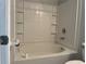 A bathtub with white tile walls and built-in shelving provides a clean and functional space at 17301 Waldrop Cv, Decatur, GA 30034