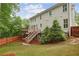 Grassy backyard featuring mature trees, a wooden fence, and a deck with stairs to the upper level at 2585 Drew Valley Ne Rd, Brookhaven, GA 30319