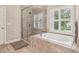 Bathroom with glass-enclosed shower and a soaking tub with marble surround at 2585 Drew Valley Ne Rd, Brookhaven, GA 30319