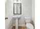 Half bath featuring a pedestal sink, toilet, framed mirror, and new hardware at 2585 Drew Valley Ne Rd, Brookhaven, GA 30319