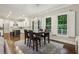 A dining area with a dark wood table, chairs, and a modern chandelier adjacent to an open kitchen with white cabinetry at 2585 Drew Valley Ne Rd, Brookhaven, GA 30319