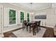 Dining area with a dark wood table, chairs, and a modern chandelier with windows providing natural light at 2585 Drew Valley Ne Rd, Brookhaven, GA 30319
