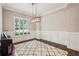 A home office with a piano, wainscoting, a modern light fixture, and natural light from a large window at 2585 Drew Valley Ne Rd, Brookhaven, GA 30319