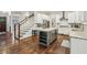 A modern, open kitchen with white cabinetry, stainless steel appliances, and an island, seamlessly connected to the staircase at 2585 Drew Valley Ne Rd, Brookhaven, GA 30319