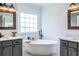 Beautiful bathroom featuring a stand alone tub, mirrors with wooden frames, and shiplap walls at 3845 Glen Ian Dr, Loganville, GA 30052