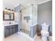 Bathroom features glass shower, gray cabinets, and stylish wood framed mirror at 3845 Glen Ian Dr, Loganville, GA 30052