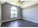 Bedroom featuring hardwood floors, gray walls, trim, and arched window at 3845 Glen Ian Dr, Loganville, GA 30052
