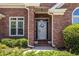 Close-up of the front door, showcasing the brick facade and charming details with manicured bushes at 3845 Glen Ian Dr, Loganville, GA 30052