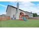 Backyard view featuring a playset, rear home elevation, and lawn at 1173 Gaines St, Jonesboro, GA 30238