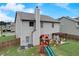 Back exterior view of gray house with fenced yard featuring a pergola and play set on lush green grass at 1173 Gaines St, Jonesboro, GA 30238