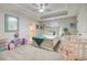 Cozy bedroom with a tray ceiling, ceiling fan, and adjacent bathroom with a rainbow shower curtain at 1173 Gaines St, Jonesboro, GA 30238