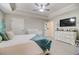 Bedroom with a tray ceiling, fan, crib, dresser, and en-suite bathroom access at 1173 Gaines St, Jonesboro, GA 30238