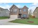 Two-story brick home with an attached two-car garage with a manicured lawn and small tree at 1173 Gaines St, Jonesboro, GA 30238