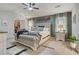 Spacious main bedroom featuring a tufted headboard, accent wall, bench, and ceiling fan at 1173 Gaines St, Jonesboro, GA 30238