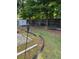 Backyard featuring a shed, tiki torches, a border of black plastic, and mature trees at 2863 Hillvale Cove Dr, Lithonia, GA 30058