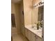 Bathroom featuring a double sink vanity, a shower, and a large mirror with Hollywood style lights at 2863 Hillvale Cove Dr, Lithonia, GA 30058