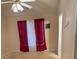 Neutral bedroom featuring carpet flooring, a window with red curtains, and a ceiling fan with a light fixture at 2863 Hillvale Cove Dr, Lithonia, GA 30058