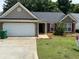 Charming single-story home featuring a two-car garage, brick accents, and a well-maintained lawn at 2863 Hillvale Cove Dr, Lithonia, GA 30058