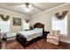 Cozy bedroom with two beds, an armchair, a ceiling fan, and hardwood floors at 3332 Heathchase Ln, Suwanee, GA 30024
