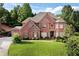 Beautiful brick home featuring a well-manicured lawn, mature landscaping, and charming curb appeal at 3332 Heathchase Ln, Suwanee, GA 30024