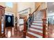 Elegant foyer boasts hardwood floors, staircase with iron spindles, and a grand, two-story entry at 3332 Heathchase Ln, Suwanee, GA 30024