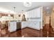 Charming white kitchen features an island with stainless steel dishwasher and hardwood floors at 3332 Heathchase Ln, Suwanee, GA 30024