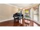 Sunlit room with a grand piano, chandelier, and elegant window treatments at 3332 Heathchase Ln, Suwanee, GA 30024