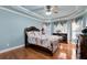 Comfortable main bedroom with dark wood furniture, hardwood floor, and a ceiling fan at 3332 Heathchase Ln, Suwanee, GA 30024