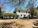 Spacious backyard of white two-story home with healthy green bushes, under a sunny blue sky at 415 Wood Trace Ct, Alpharetta, GA 30022