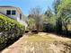 Backyard with wood deck is nestled among healthy green trees and bushes, with a brick walkway at 415 Wood Trace Ct, Alpharetta, GA 30022