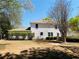 Large backyard of a white two-story home is enhanced by green bushes and mature shade trees at 415 Wood Trace Ct, Alpharetta, GA 30022