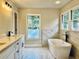Bright bathroom with a soaking tub, marble accents, and a dual sink vanity at 415 Wood Trace Ct, Alpharetta, GA 30022