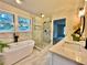 Bright bathroom with a soaking tub, glass shower, and modern tile flooring at 415 Wood Trace Ct, Alpharetta, GA 30022