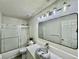 Modern bathroom with marble sink, unique lighting, and tiled shower with glass door at 415 Wood Trace Ct, Alpharetta, GA 30022