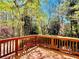 View from the house's wood deck, with wood railings, overlooking the wooded backyard at 415 Wood Trace Ct, Alpharetta, GA 30022