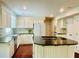 Kitchen features a center island with black countertops, white cabinets, and stainless steel appliances at 415 Wood Trace Ct, Alpharetta, GA 30022