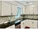 Well-lit kitchen with granite countertops, modern backsplash, and stainless steel dishwasher at 415 Wood Trace Ct, Alpharetta, GA 30022