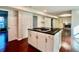 Updated kitchen island has cooktop, dark countertops, and leads to a living room with fireplace at 415 Wood Trace Ct, Alpharetta, GA 30022