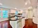 Updated kitchen featuring a central island with a stovetop, white cabinets, and dark granite countertops at 415 Wood Trace Ct, Alpharetta, GA 30022
