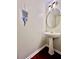 Stylish powder room featuring a pedestal sink, decorative mirror, and modern lighting at 415 Wood Trace Ct, Alpharetta, GA 30022