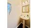 Neat powder room featuring a pedestal sink, vanity mirror, and stylish lighting at 415 Wood Trace Ct, Alpharetta, GA 30022