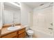 Traditional bathroom with warm-toned cabinets, a sink, toilet, and bathtub/shower combination at 85 Old Gettysburg Way, Dallas, GA 30157