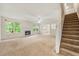 Bright living room with a fireplace, a fan, and an adjacent stairway to the upper level at 85 Old Gettysburg Way, Dallas, GA 30157
