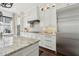 Bright kitchen featuring white cabinets, stainless steel appliances, and a large island with a marble countertop at 1241 Hightower Nw Xing, Marietta, GA 30060