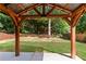 Inviting backyard featuring a charming wooden pergola with string lights and a lush green lawn, perfect for outdoor relaxation at 3415 Kenyon Creek Nw Dr, Kennesaw, GA 30152